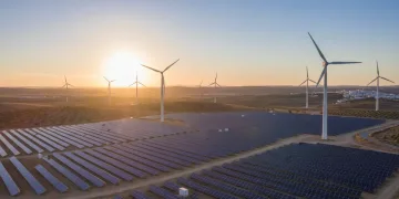 Parque solar y eólico moderno en España al atardecer, representando el futuro energético renovable.