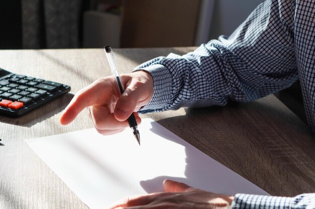 A person filling out a tax form with a pen, with emphasis on the sections related to child tax credits. The setting is a home office, suggesting the accessibility and straightforward nature of claiming the credit.