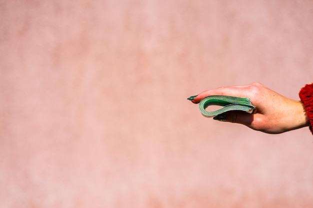 A close-up of a hand adding money to a jar labeled 