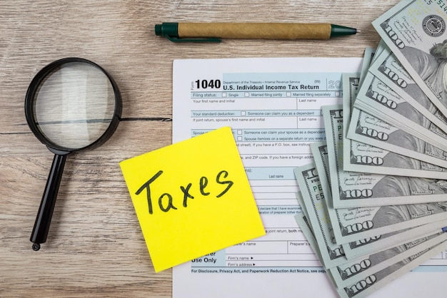 A close-up view of a US tax form related to capital gains, partially filled out with numbers and calculations. A pen rests on the form, and a small pile of cryptocurrency coins is visible in the background. The lighting is focused on the form, highlighting the importance of accurate reporting.