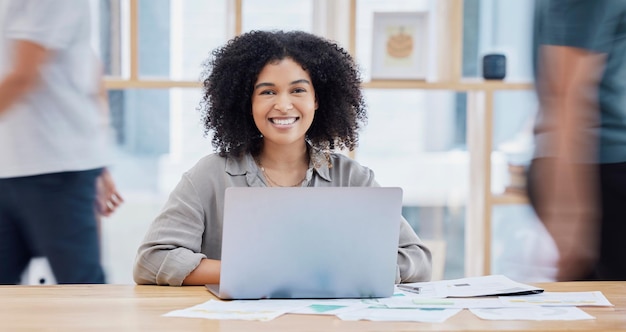 An office worker smiling while looking at a computer screen, signifying the benefits of employer-sponsored education programs for career development and improved job prospects.