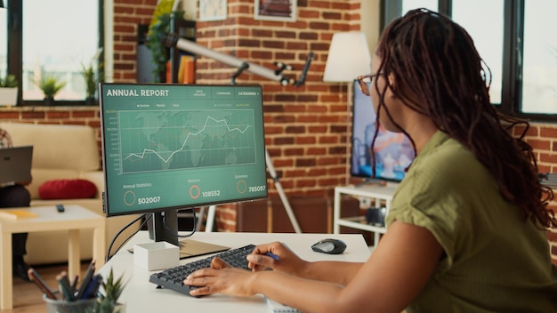 A person working at a computer with charts and graphs visible on the screen, representing the research and planning involved in understanding student loan forgiveness options.