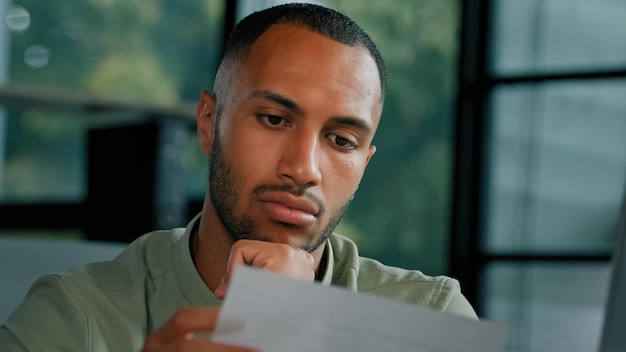 A close-up shot of an employee looking concerned while checking their paycheck. The background is blurred, focusing on the employee's expression of worry and confusion, symbolizing uncertainty about overtime pay and eligibility.