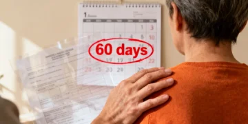 Supportive hand on shoulder with documents, symbolizing survivor benefits claim process.